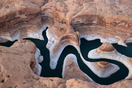 Aerial view of drought conditions in lake snaking through a rocky canyon