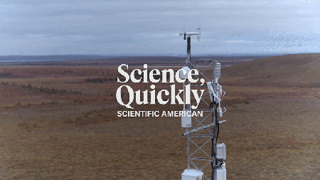 An aerial view of an instrumentation tower with wind gauges and sensors set in a rolling brown and red landscape