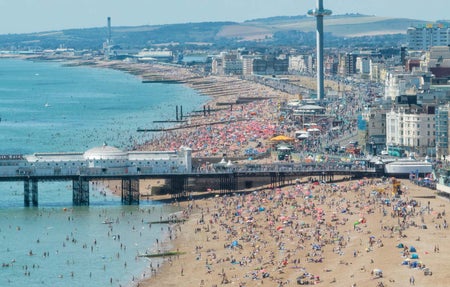 Beachgoers crowd the seashore in Brighton, England, in July 2022.