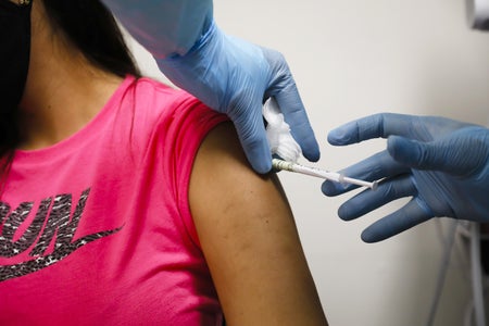 A health worker injects a person during clinical trials for a Covid-19 vaccine