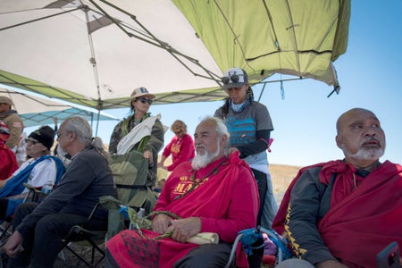 A group of protestors gathering under sun shade