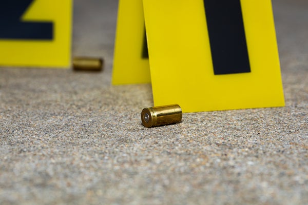 Stock image, gun shell casing at crime scene with numbered evidence flags on ground