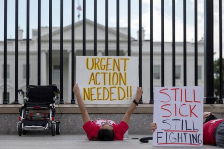 Protestors laying down holding up signs