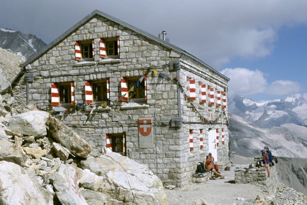 Small stone building with red and white shutters