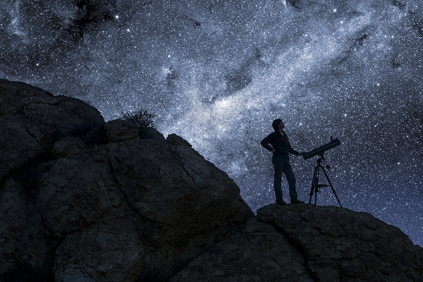 Man Stargazing in Desert