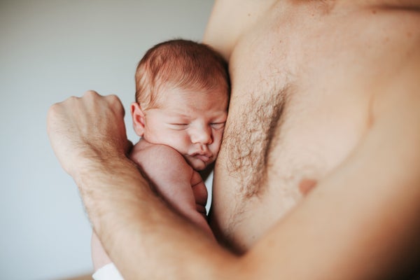 Newborn baby on father's bare chest.