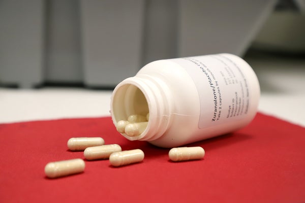 Pills spilling out of medicine bottle on table