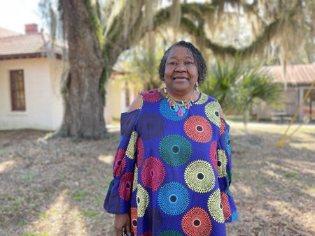 Joanne Heyward stands in front of tree