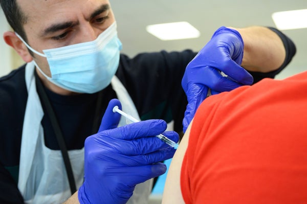 Close up of man receiving vaccine shot.