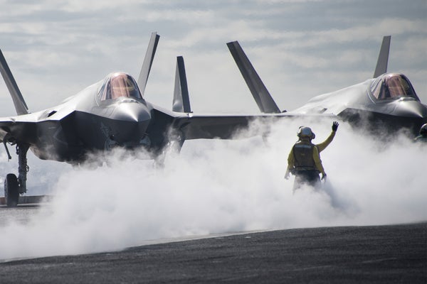 Sailors on aircraft carrier direct stealth jets