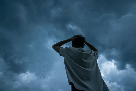 Man looking up storm cloud