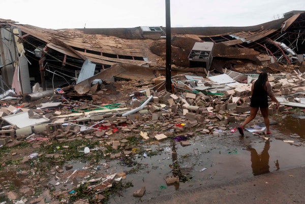 Collapsed house surrounded by debris