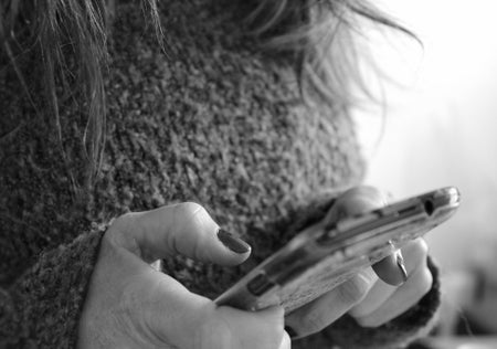 Midsection of a woman using a mobile phone.