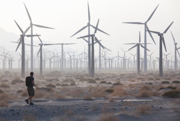 Person walking through wind farm in desert