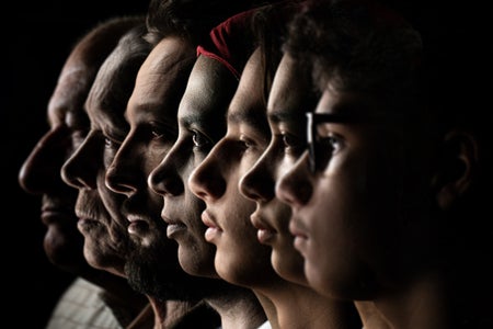Profile view of multiple people on black background.