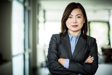 A businesswoman smiles at the camera.