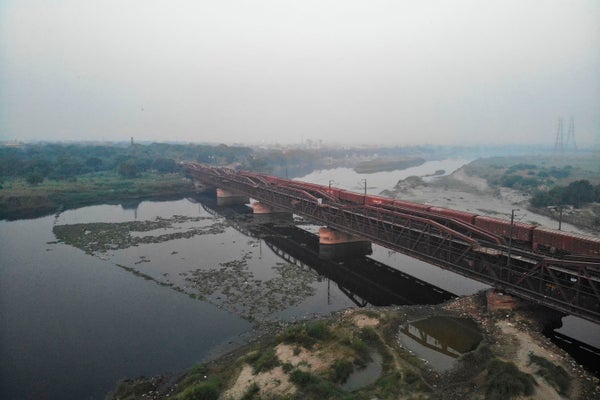 An aerial view of a train crossing a river in India.