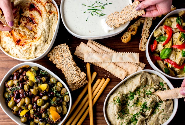 Mezze platter. Hummus, Tzatziki, olives, roasted peppers. Mediterranean dips served w/ pita bread, bell peppers & vegetables.