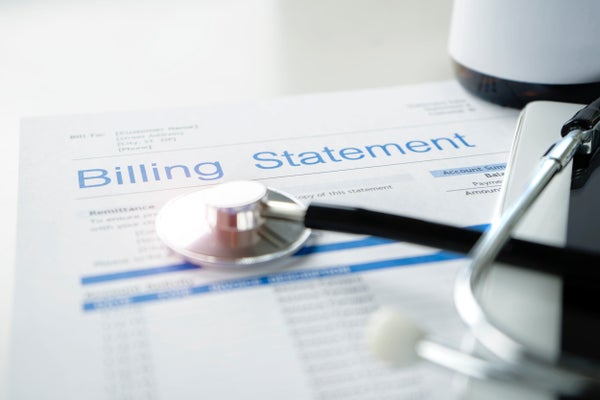 Closeup of a stethoscope lying on a piece of paper marked "Billing Statement."