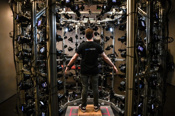 Person standing in cagelike structure comprised of cameras