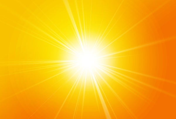 A bright sun with flare against a yellow background.
