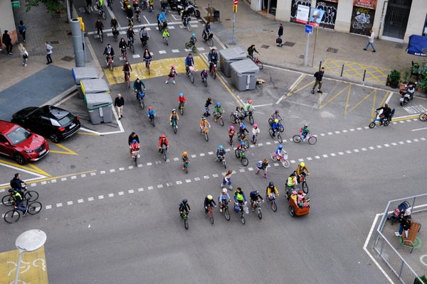 Aerial view of kids and parents riding bikes across city street