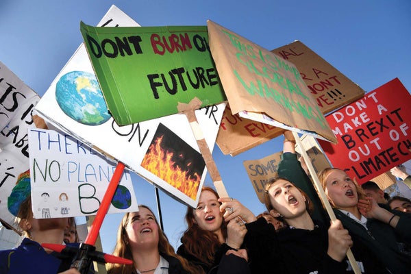 Schoolchildren hold placards and chant as they attend a climate change protest