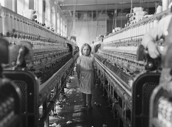 A child stands amid industrial machinery in a factory interior setting.