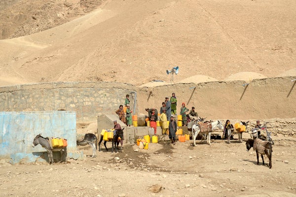 Children fill jerrycans with water during a drought in Afghanistan