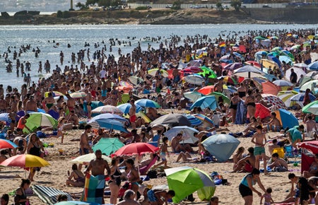 A beach crowded with beach goers.