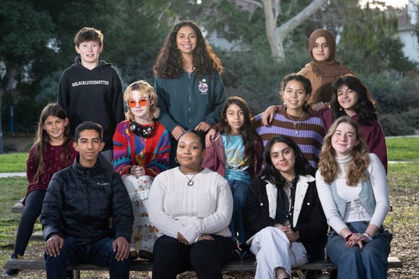 Twelve of the 18 young climate activists at a bench outdoors.