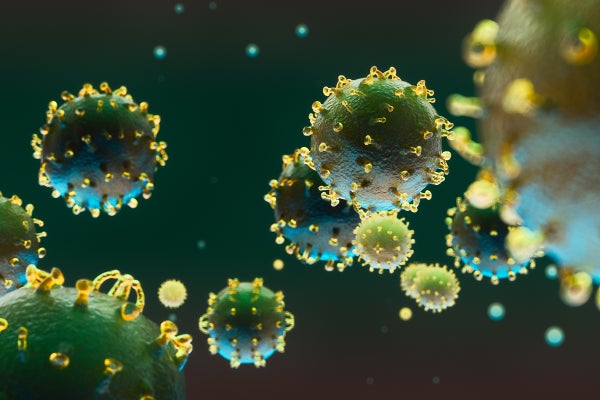 Spiky green and yellow coronavirus particles float through the frame.