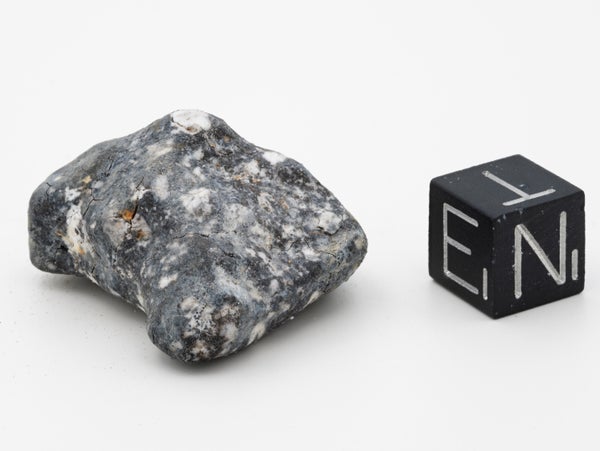 A fragment of Asteroid 2024 next to a black cube with the letters E N T