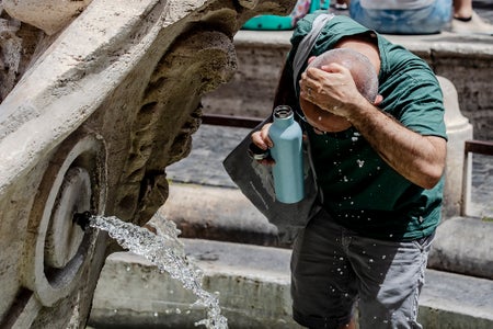 Man cooling off splashing  cold water on his head.