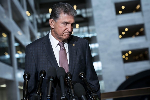 Senator Joe Manchin departs from a news conference.