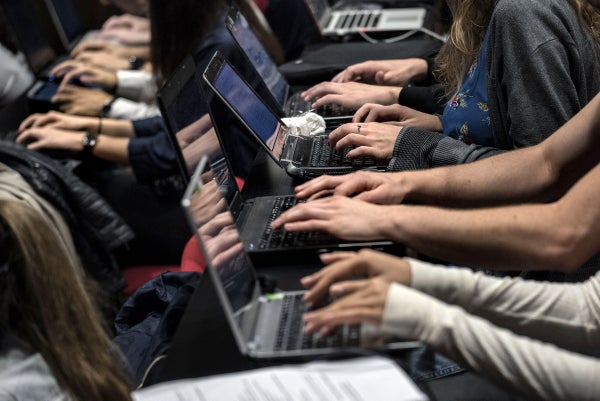 University students use laptops to take notes in a classroom