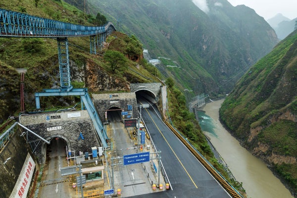 Entrance to the Jinping tunnels with three arches and green mountainous backdrop.