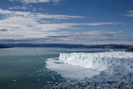Jagged blue ice face of Eqip Glacier along Disko Bay on summer afternoon, Ilulissat, Greenland.