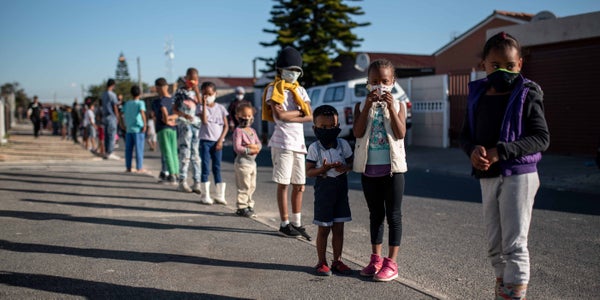 Children wait for a cooked meal from the charity Khathalelana in Delft, South Africa