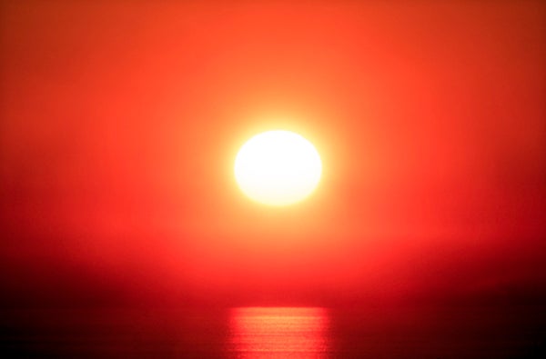 Close-up of a red sunset in a the fog above the Pacific Ocean