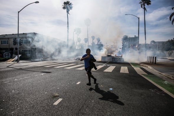 A protester runs from tear gas launched from police near the California Incline during a protest against the killing of George Floyd. Protesters took to the streets of Los Angeles for the fifth day in a row in a stance against the killing of George Floyd by former Minneapolis police officer, Derek Chauvin. Credit: Stanton Sharpe Getty Images