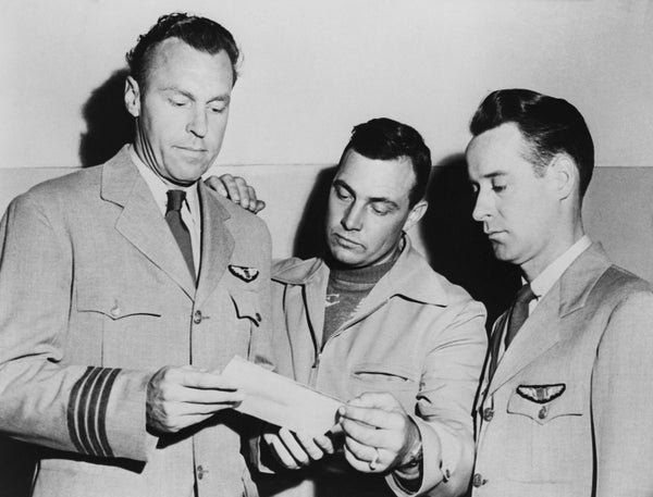 Three pilots look at a photo of a UFO