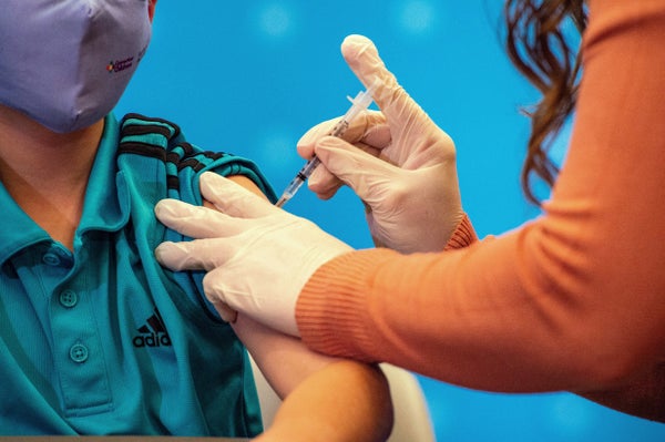 Close up of child receiving vaccine in arm.
