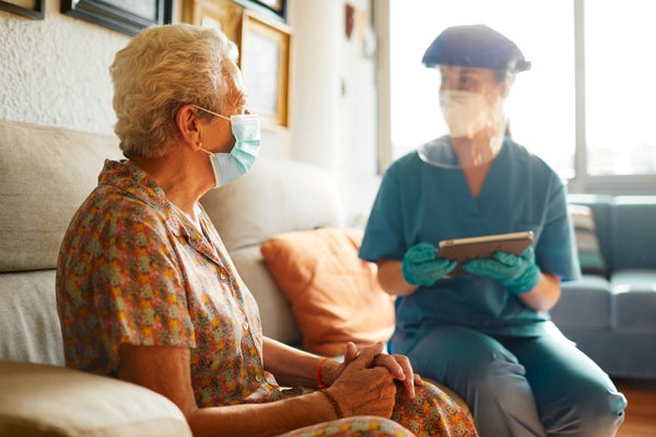 A female health care worker visits a senior woman at a nursing home.