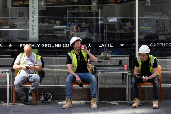 Workmen take a break outside a cafe, during a heat wave, in London