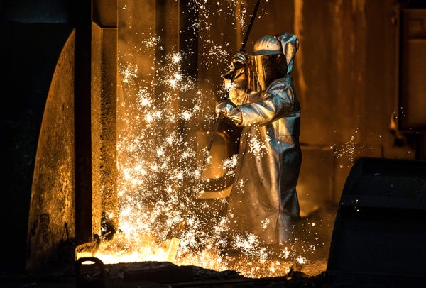 A worker oversees molten iron flowing from a blast furnace at the ThyssenKrupp steel mill