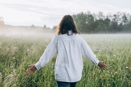 Rear view of woman walking in a rural field