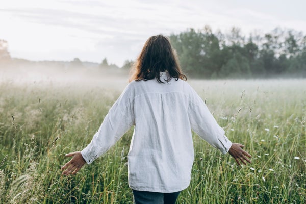 Rear view of woman walking in a rural field