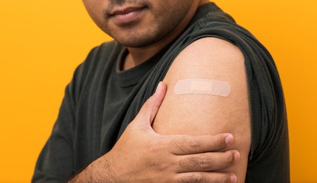 Close up of man showing arm with bandage plaster