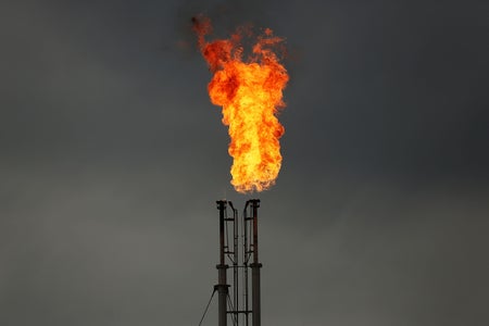 Natural gas is flared off into grey skies.